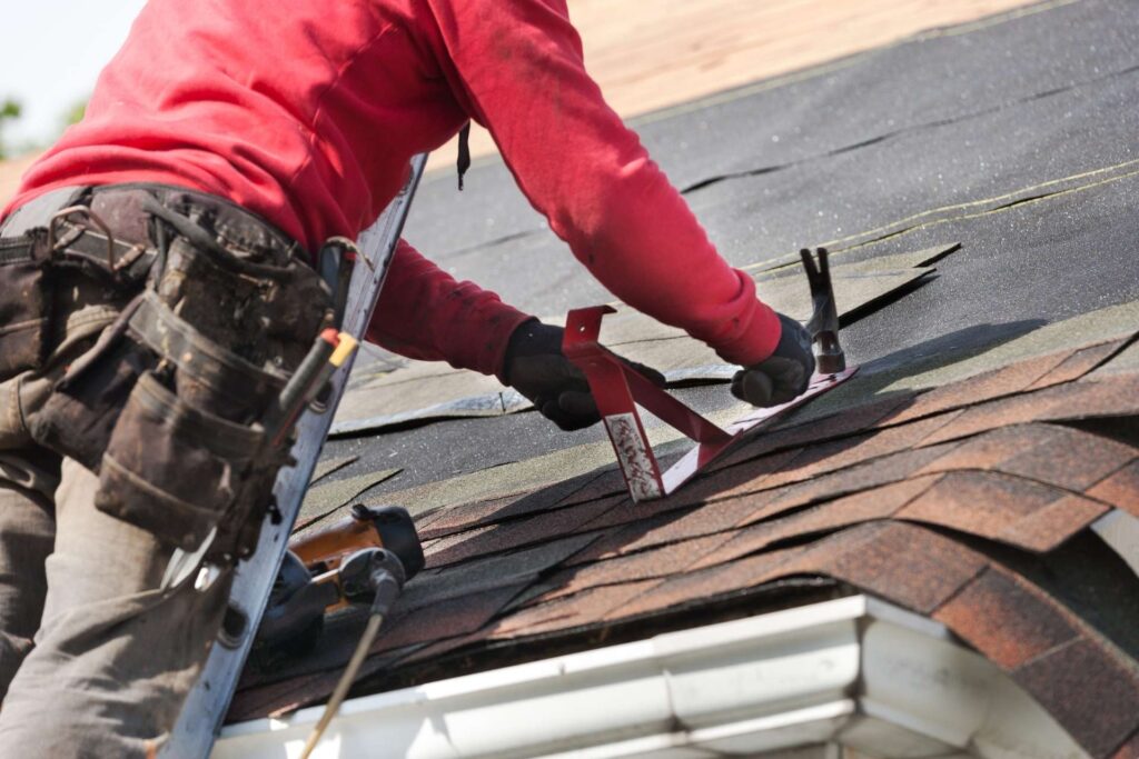 person standing on a rooftop at sunset, representing McKinney roofing services